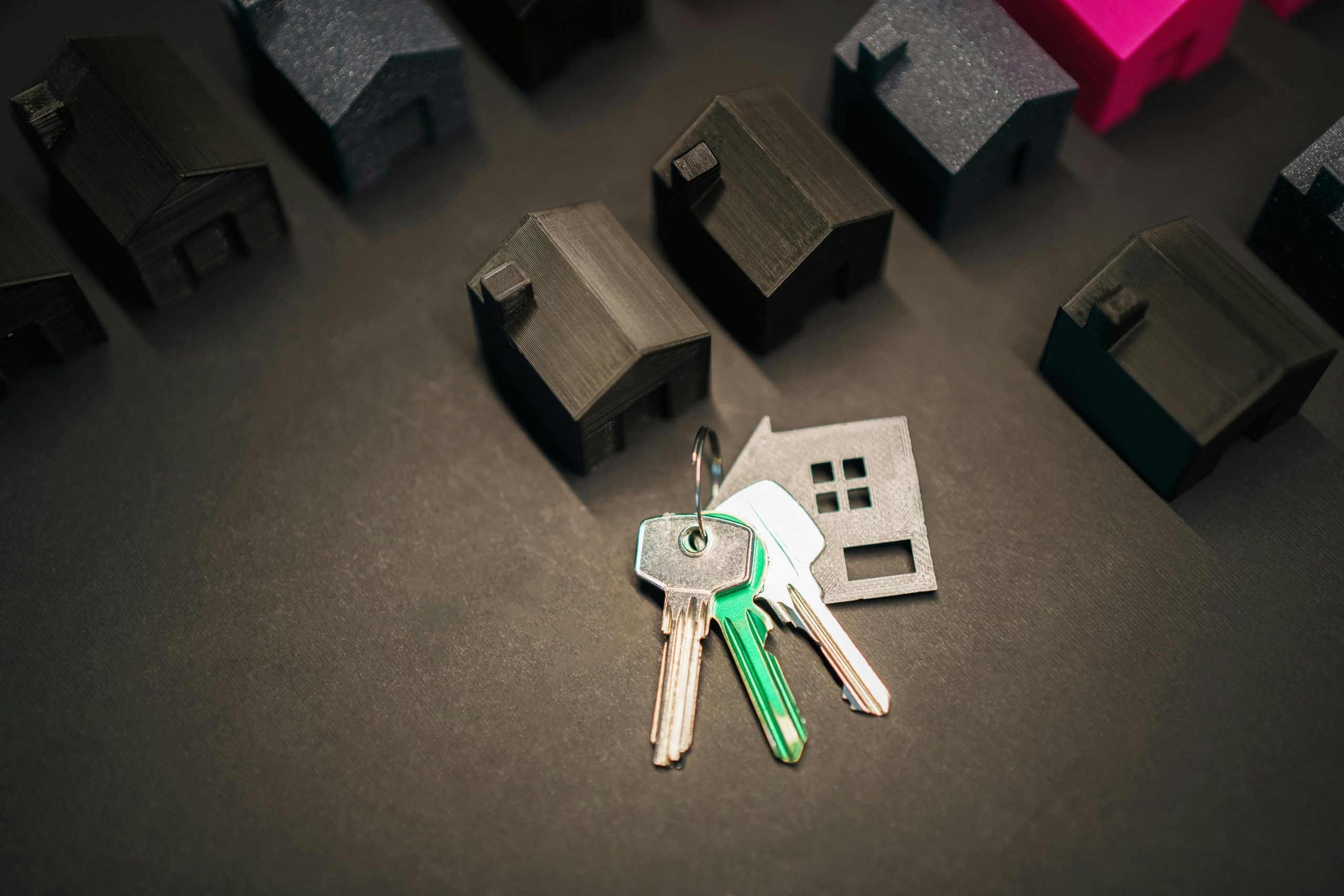 key with a house-shaped keychain surrounded by black house-shaped meeples